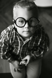 poza alb negru copil cu ochelari mari