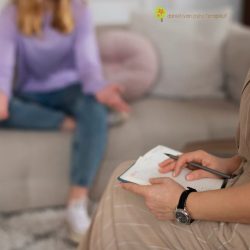 femeie pe canapea discutand cu psihoterapeutul